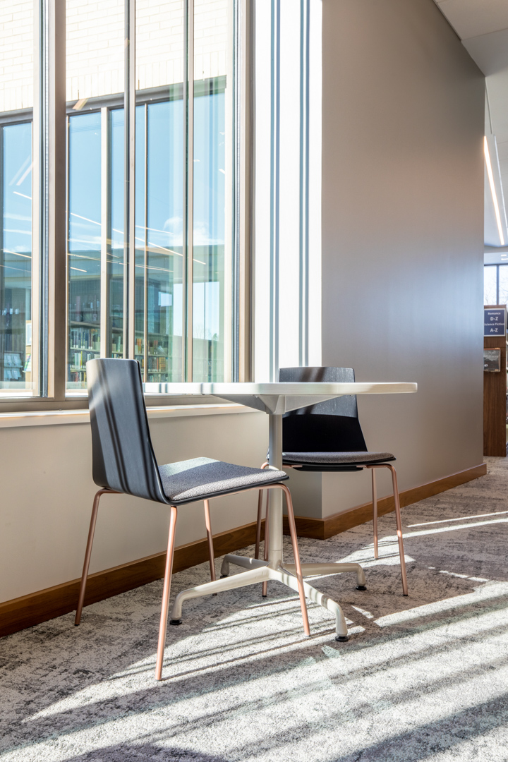 Table and chairs next to a library window